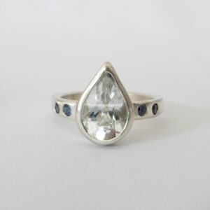 White topaz pear ring with blue sapphires in sterling silver