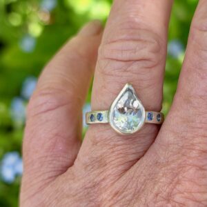 Brazilian white topaz pear ring with blue sapphires in sterling silver. Size N