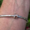Roller Bangle; 3.5mm solid silver with 9ct red gold and silver. Internal diameter 64mm - Image 2