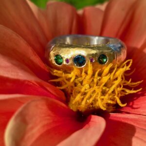 Eclipse ring; silver and 24ct gold with unheated green sapphires and ruby. Size Q