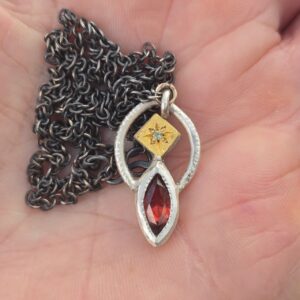 Balancing Act necklace; marquise garnet, green sapphire, silver and 24ct gold