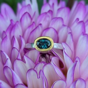 Empress Ring; unheated, ethical teal parti sapphire, peach sapphires, silver and 24ct gold. Size N