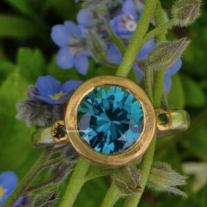 Chloris ring, blue Vietnamese zircon, green sapphire, silver, 24ct gold. Size M